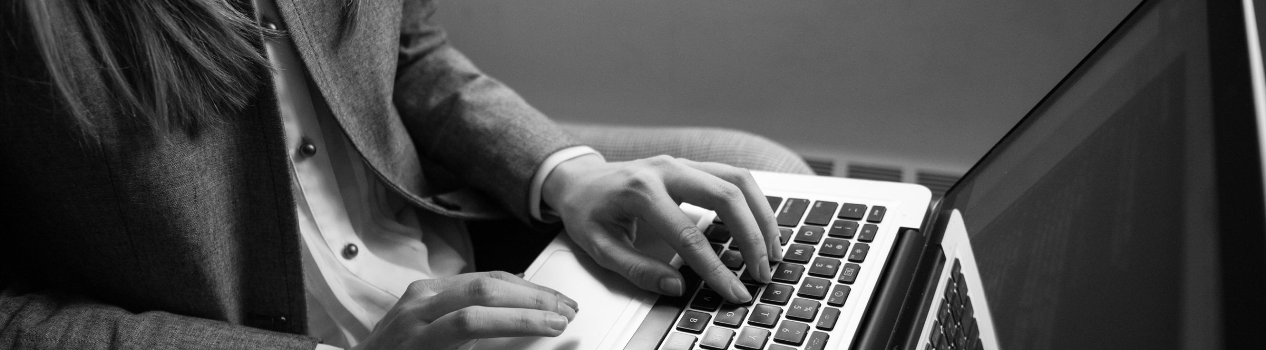 femme tapant sur le clavier de son ordinateur portable